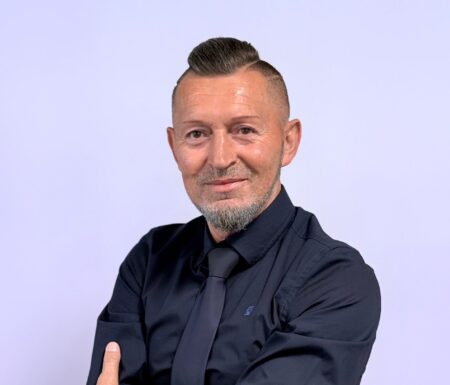 Portraitfoto eines Mannes mit dunklem Hemd und dunkler Krawatte